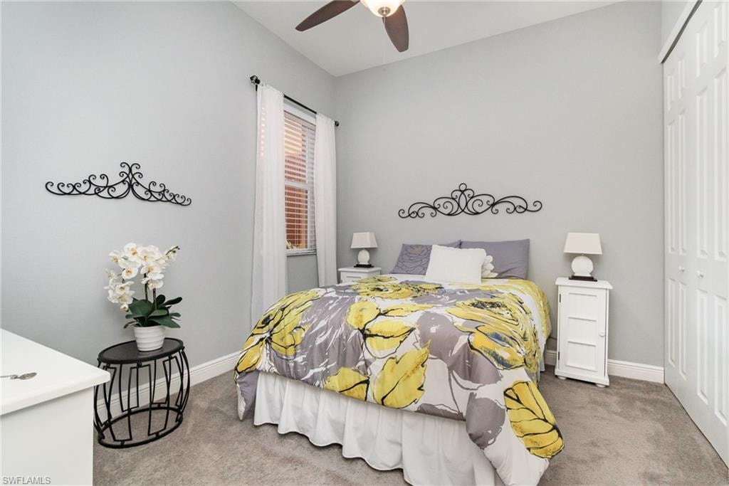 Bedroom with carpet, a closet, baseboards, and ceiling fan