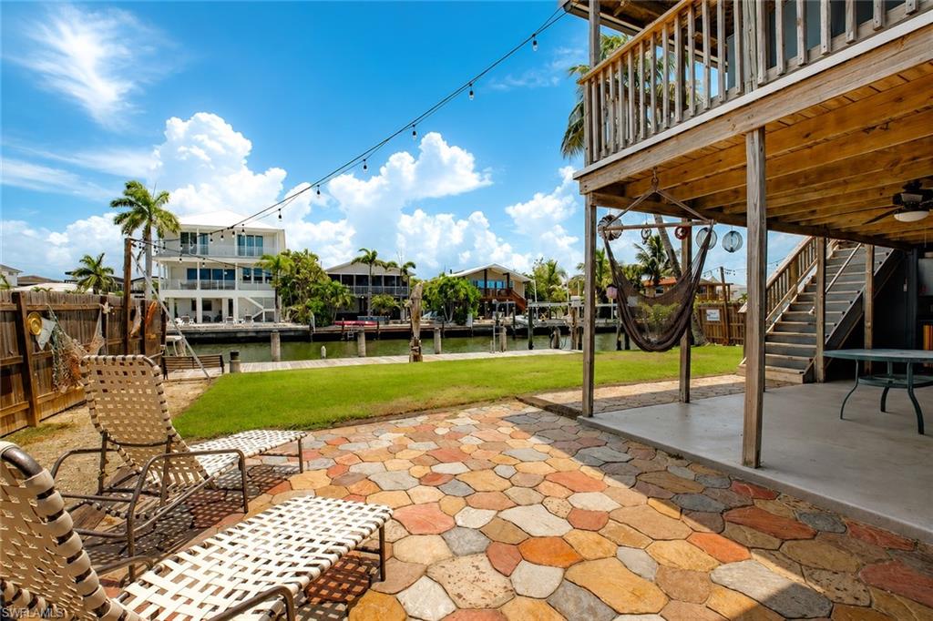 Multi-color paver patio with a manicured lawn and canal access
