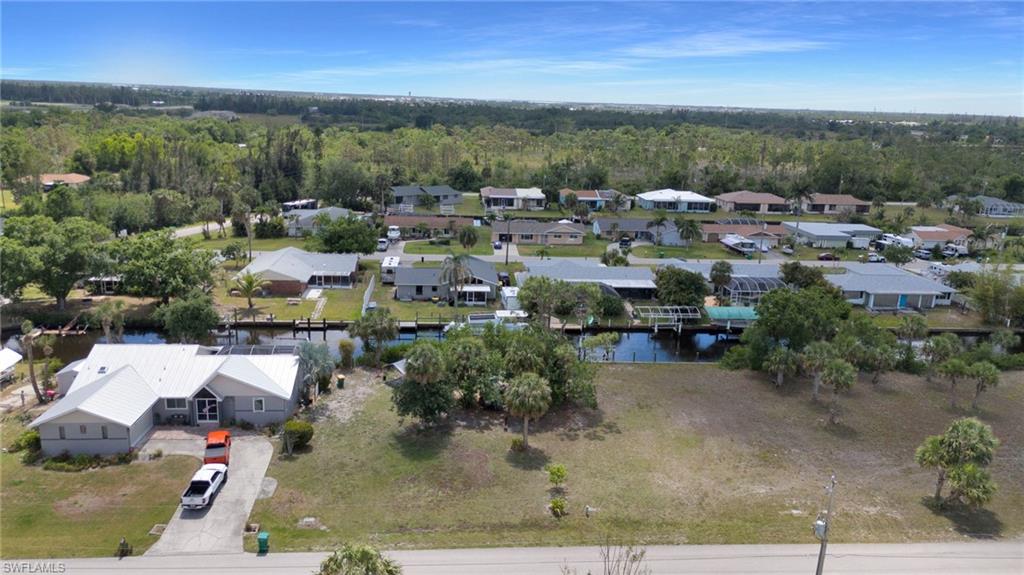 Drone / aerial view featuring a residential view, a wooded view, and a water view