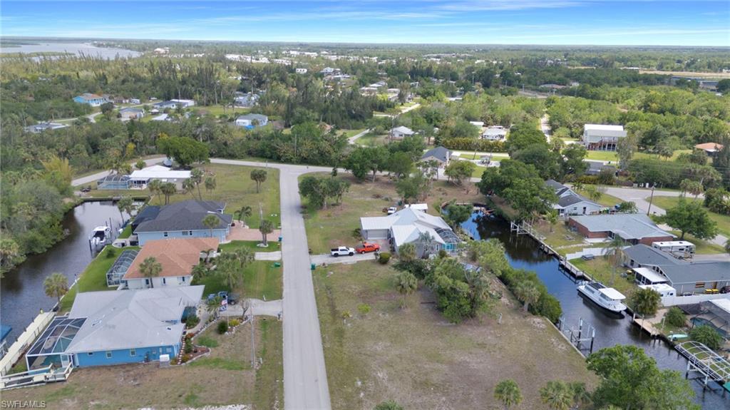 Birds eye view of property with a water view and a residential view