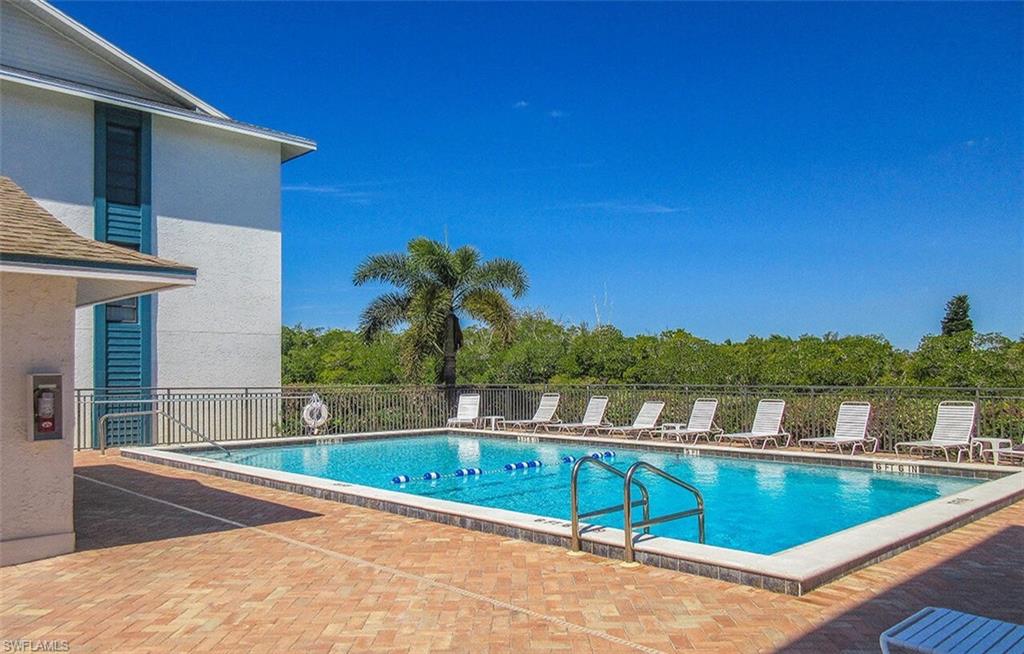 Community pool featuring a patio and fence