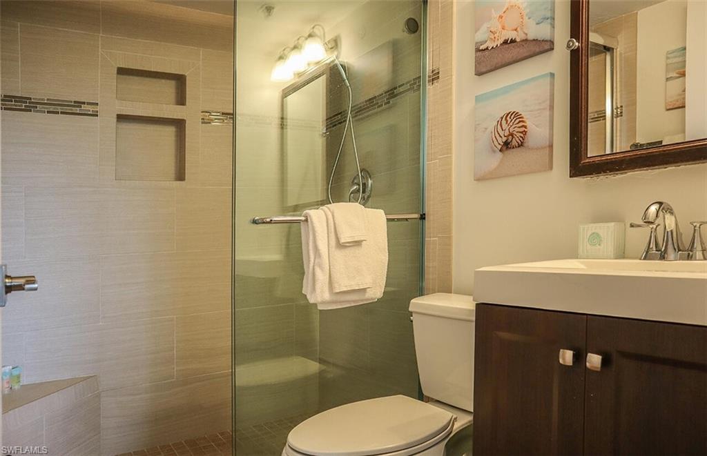 Bathroom with vanity, toilet, and a shower stall