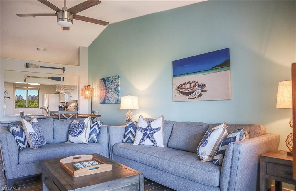 Living area with ceiling fan, wood finished floors, lofted ceiling, and visible vents