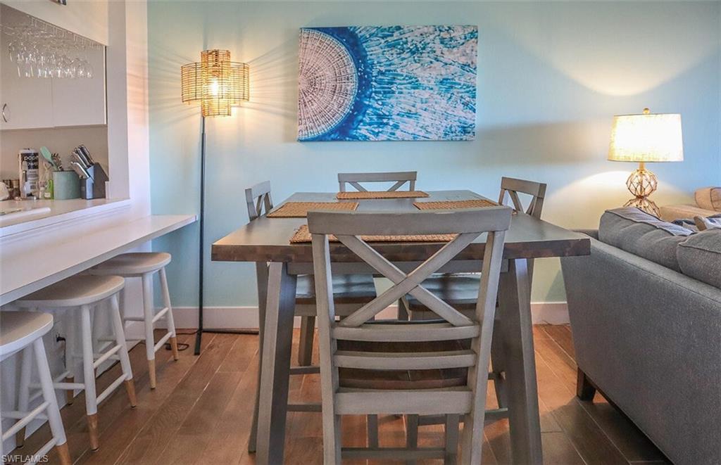 Dining room featuring baseboards, an inviting chandelier, and wood-type flooring