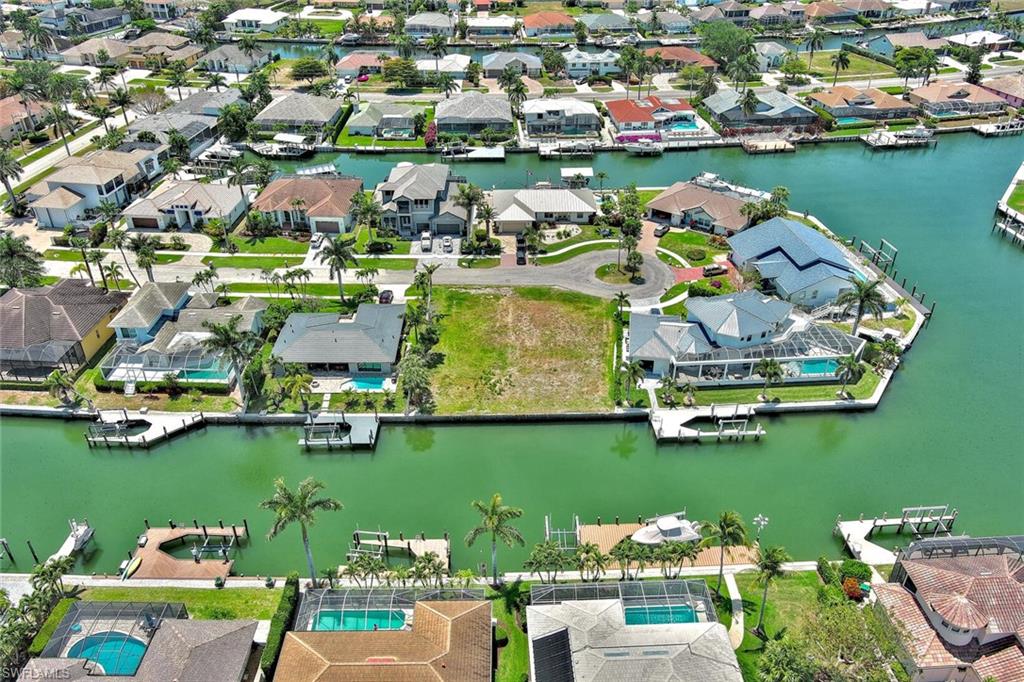 Birds eye view of property with a water view and a residential view