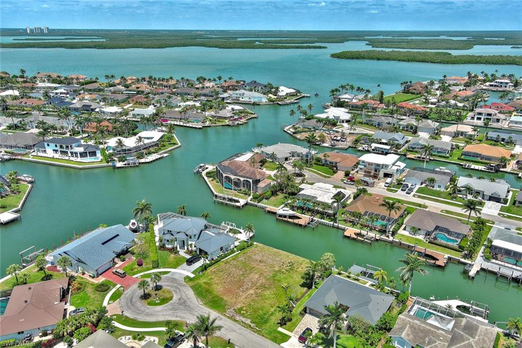 Birds eye view of property with a water view and a residential view