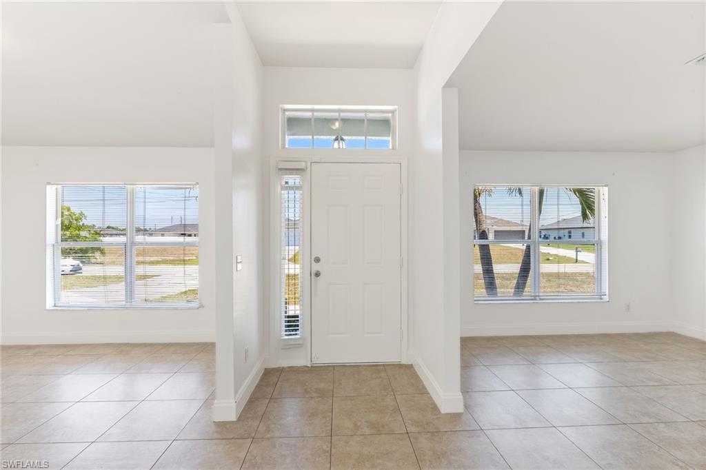 Living room on the Left-Entrance Formal Dining, foyer featuring baseboards and light tile patterned floors
