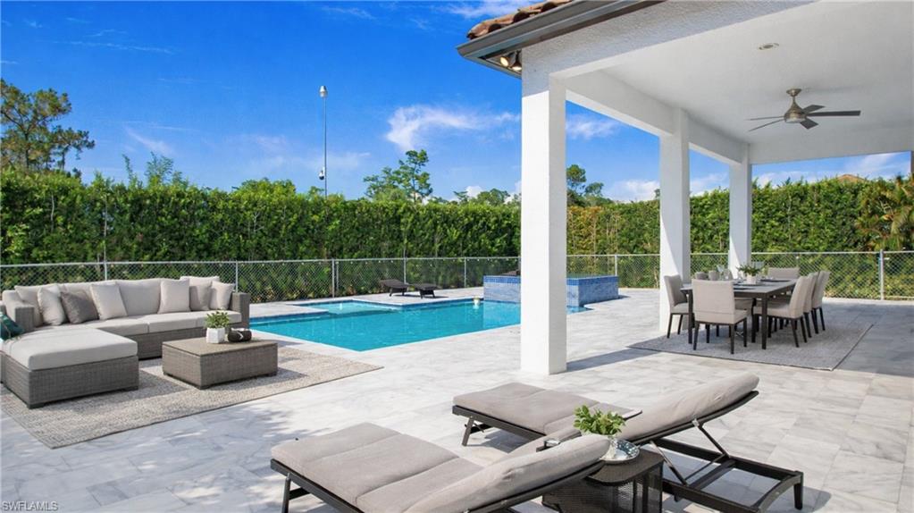 Virtually Staged  View of swimming pool featuring a fenced backyard, an outdoor living / dining area, and patio surround
