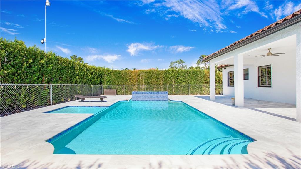 View of swimming pool with fence, a patio area, and ceiling fan