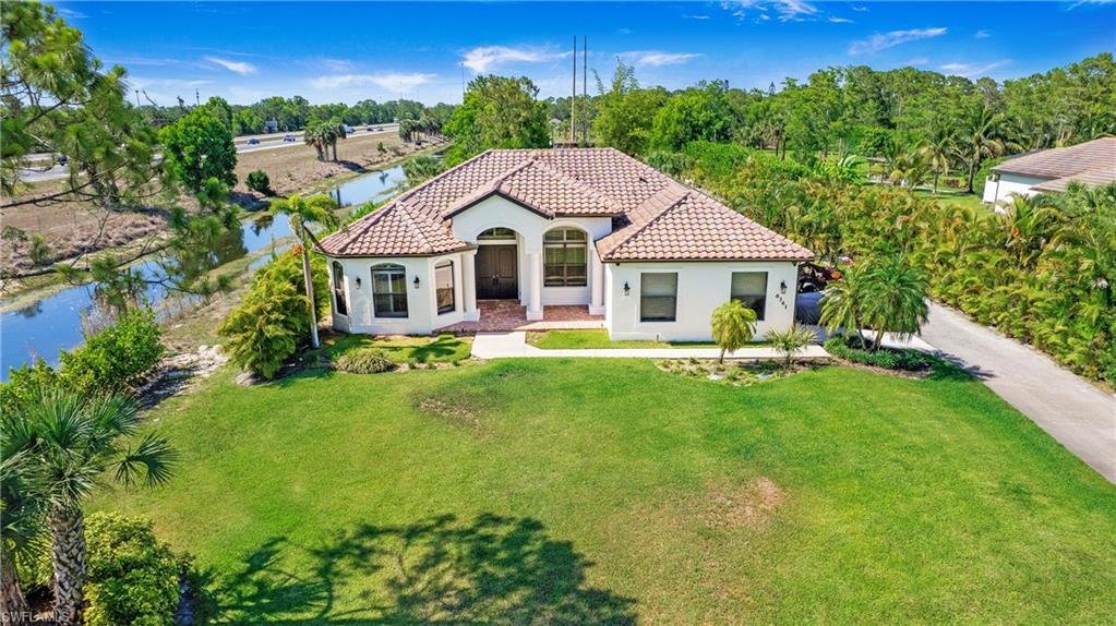 Mediterranean / spanish home with a tiled roof, stucco siding, and a front yard