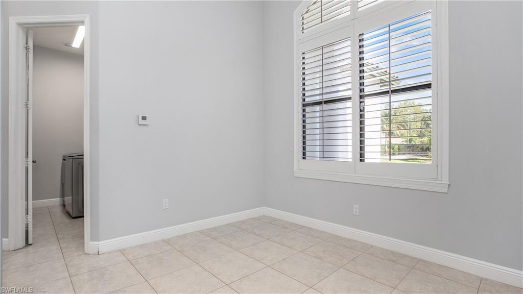 Empty room with light tile patterned flooring and baseboards