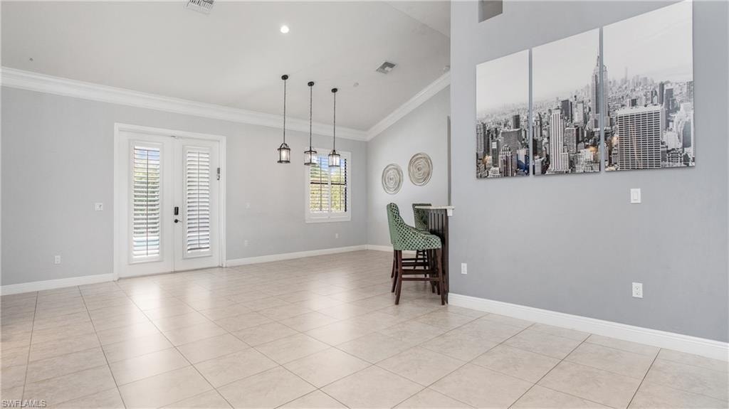 Unfurnished room with crown molding, light tile patterned floors, and baseboards