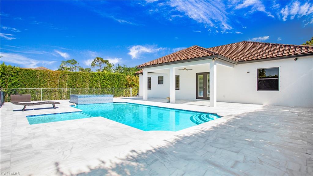 View of swimming pool featuring ceiling fan, a patio, and fence