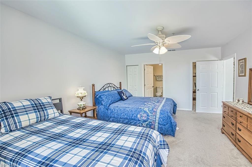 Bedroom featuring visible vents, baseboards, light colored carpet, a closet, and ceiling fan