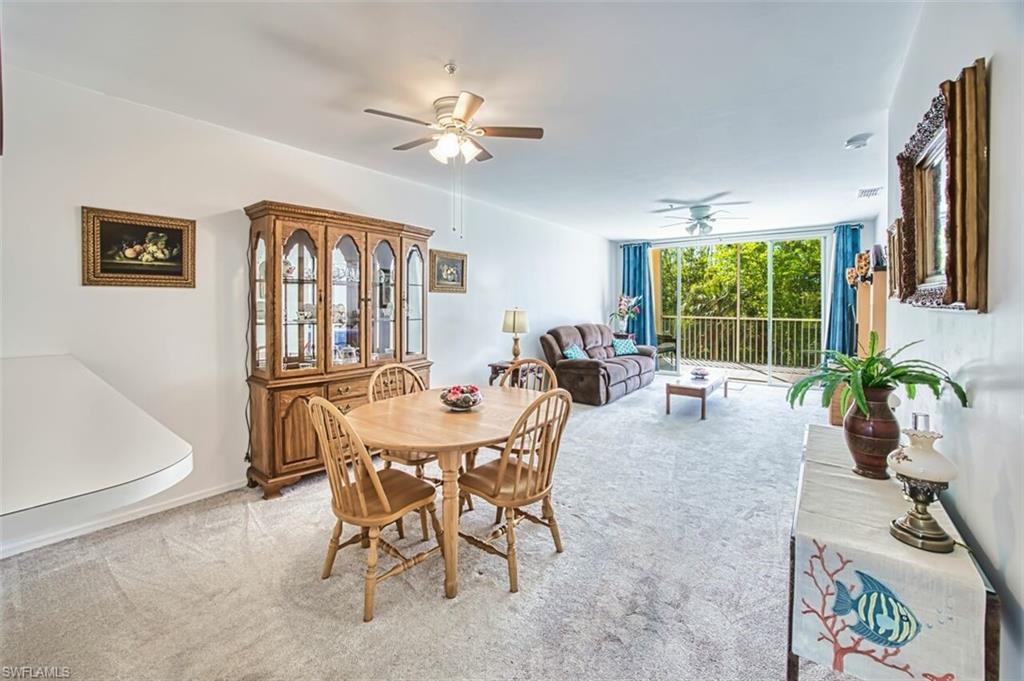 Dining room with baseboards, a ceiling fan, and light colored carpet