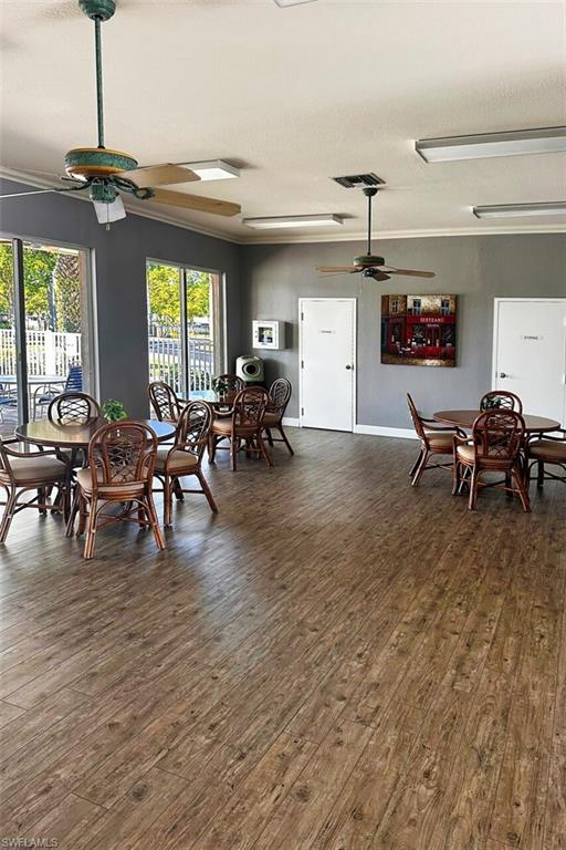 Dining space featuring a ceiling fan, dark wood-style floors, and a textured ceiling