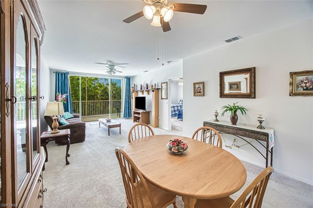 Dining space featuring baseboards, visible vents, light colored carpet, and ceiling fan
