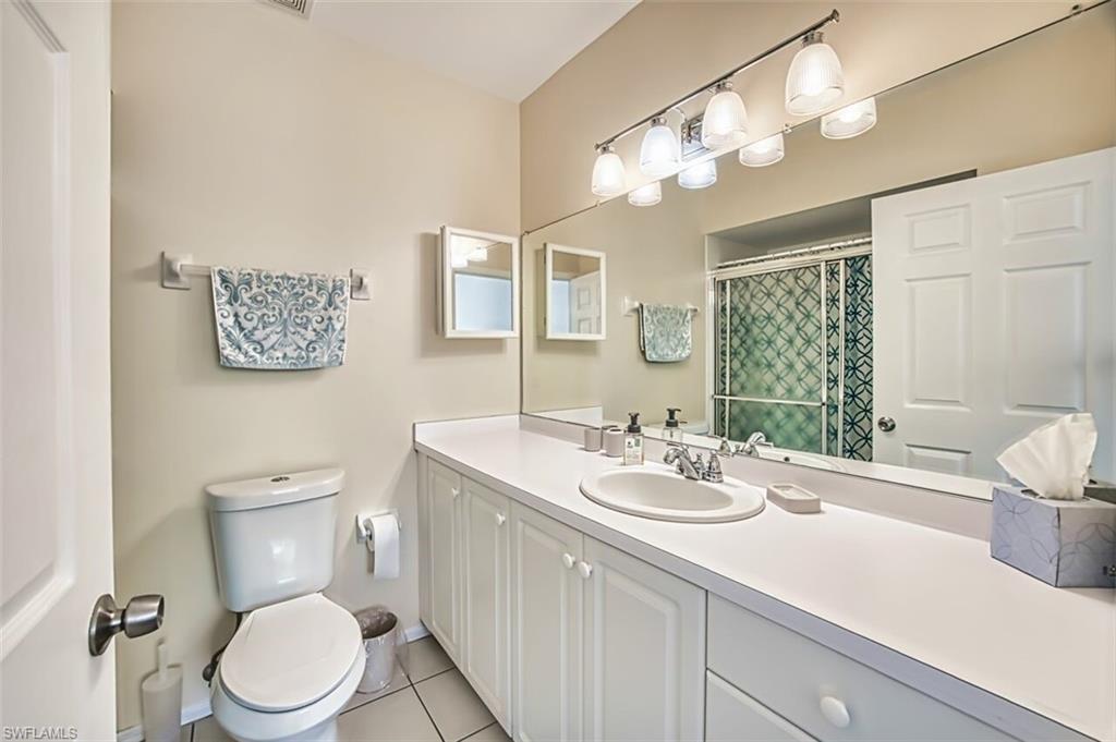 Bathroom with tile patterned floors, vanity, a shower with curtain, baseboards, and toilet