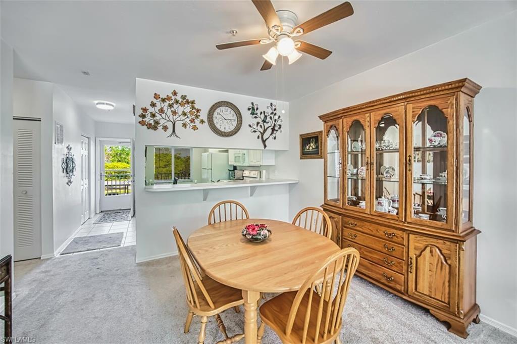 Dining room with light carpet, baseboards, and ceiling fan