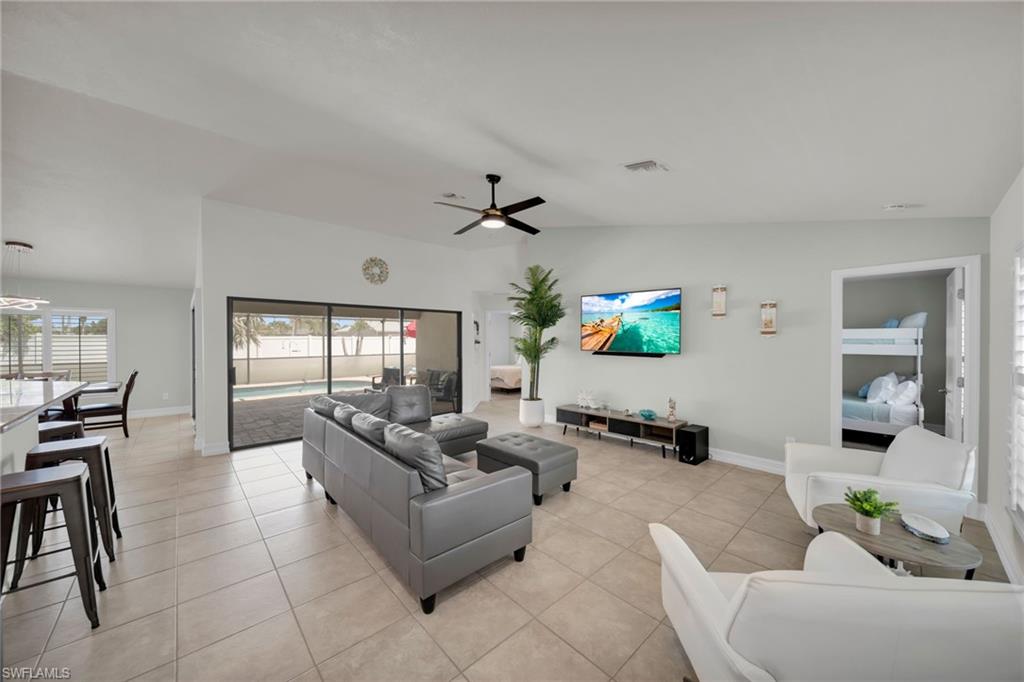 Living area with baseboards, a ceiling fan, and light tile patterned flooring