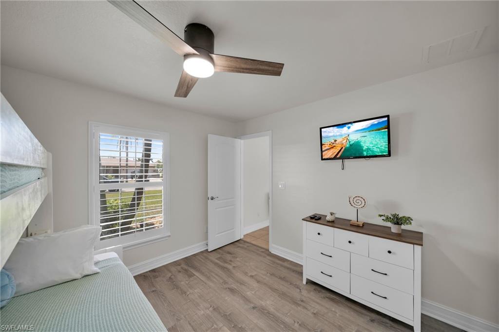 Unfurnished room featuring a ceiling fan, visible vents, baseboards, and light wood-type flooring