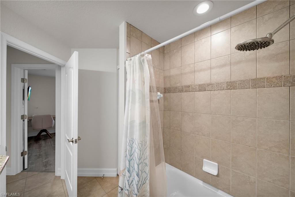 Full bath with recessed lighting, shower / bath combo, tile patterned floors, and baseboards