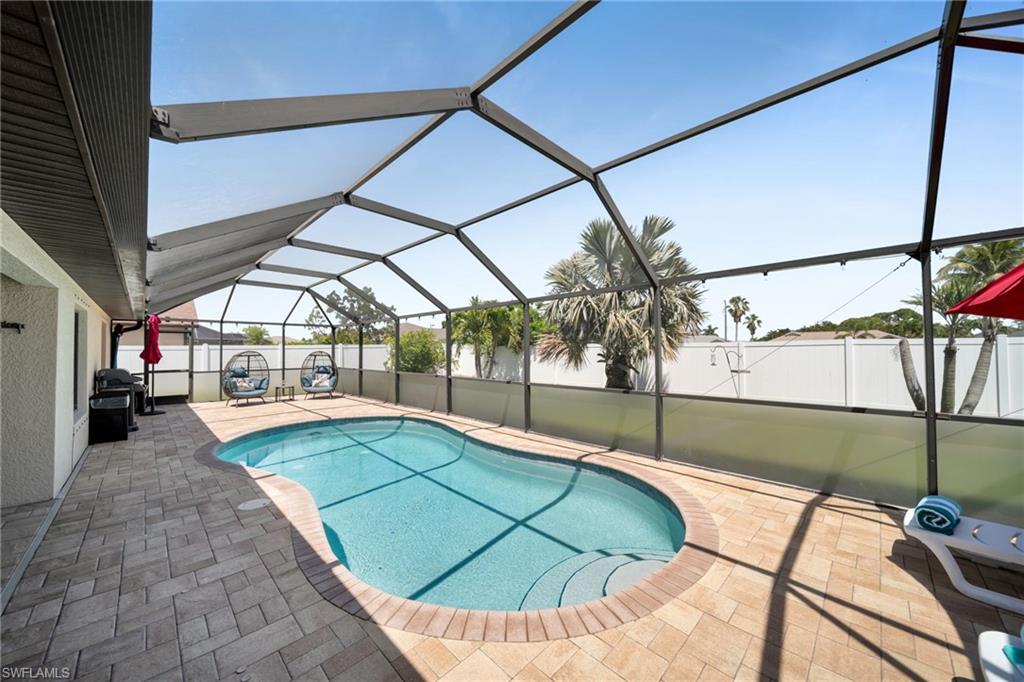 View of swimming pool with a patio, a fenced in pool, a fenced backyard, and a lanai