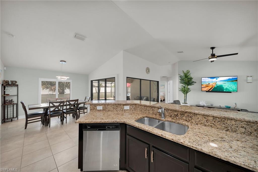 Kitchen featuring lofted ceiling, a sink, visible vents, light tile patterned flooring, and dishwasher