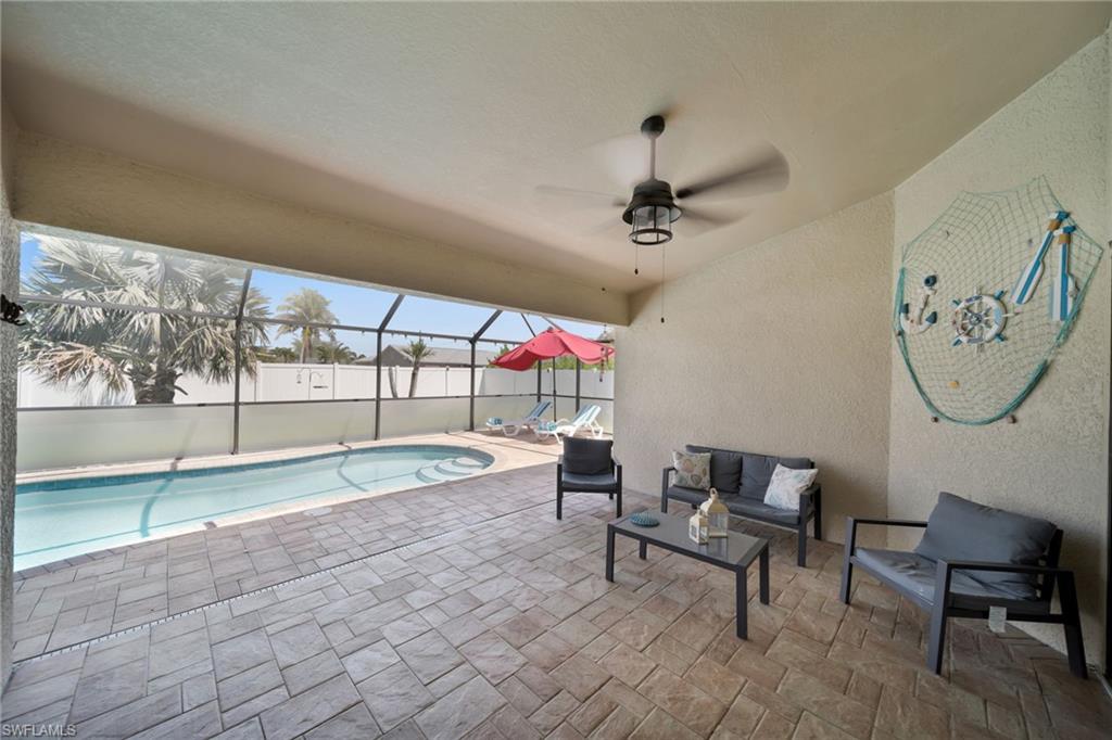 View of pool with an outdoor living space, ceiling fan, a fenced in pool, a patio area, and a lanai