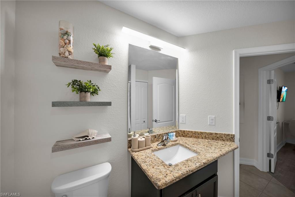 Bathroom featuring tile patterned floors, toilet, and vanity