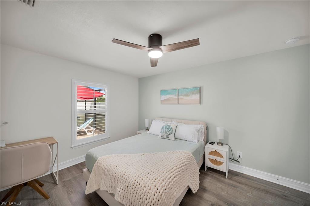 Bedroom featuring wood finished floors, a ceiling fan, visible vents, and baseboards