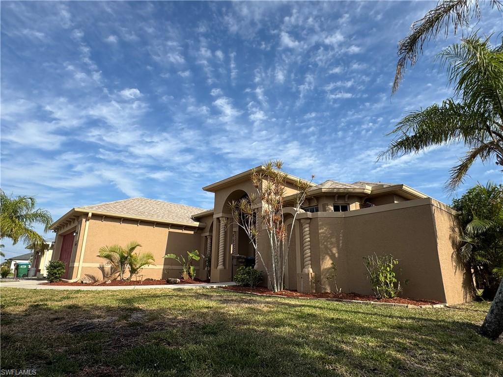 Mediterranean / spanish home featuring a front lawn, driveway, stucco siding, an attached garage, and french doors