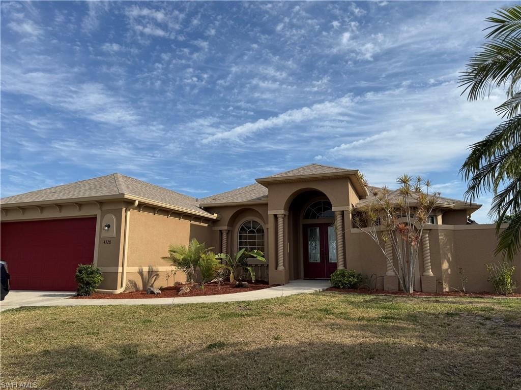 Mediterranean / spanish home featuring driveway, a front yard, stucco siding, a garage, and french doors