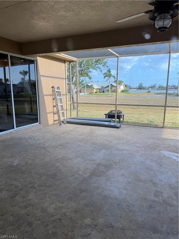 Spare room featuring dark carpet, visible vents, a ceiling fan, and baseboards