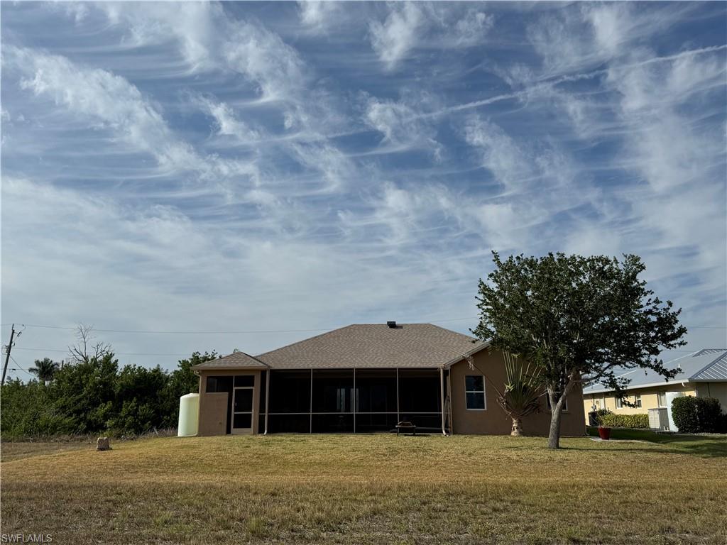 Mediterranean / spanish house with an attached garage, fence, a front yard, and stucco siding