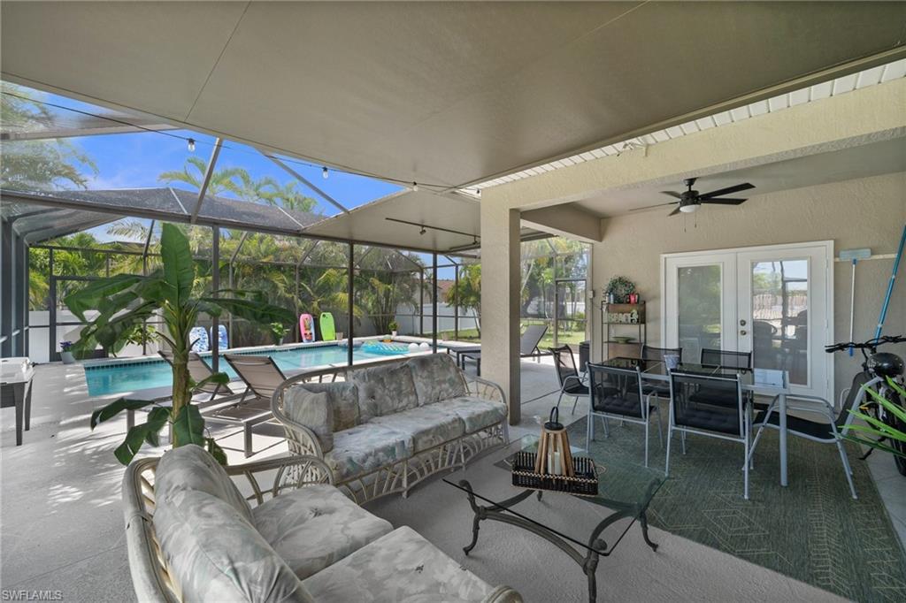 Sunroom featuring outdoor lounge area, a ceiling fan, a swimming pool, and french doors