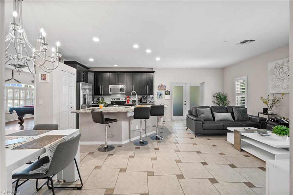 Living room featuring recessed lighting, pool table, a chandelier, and baseboards