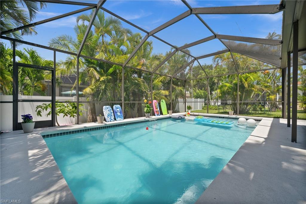 View of swimming pool featuring a patio area and glass enclosure