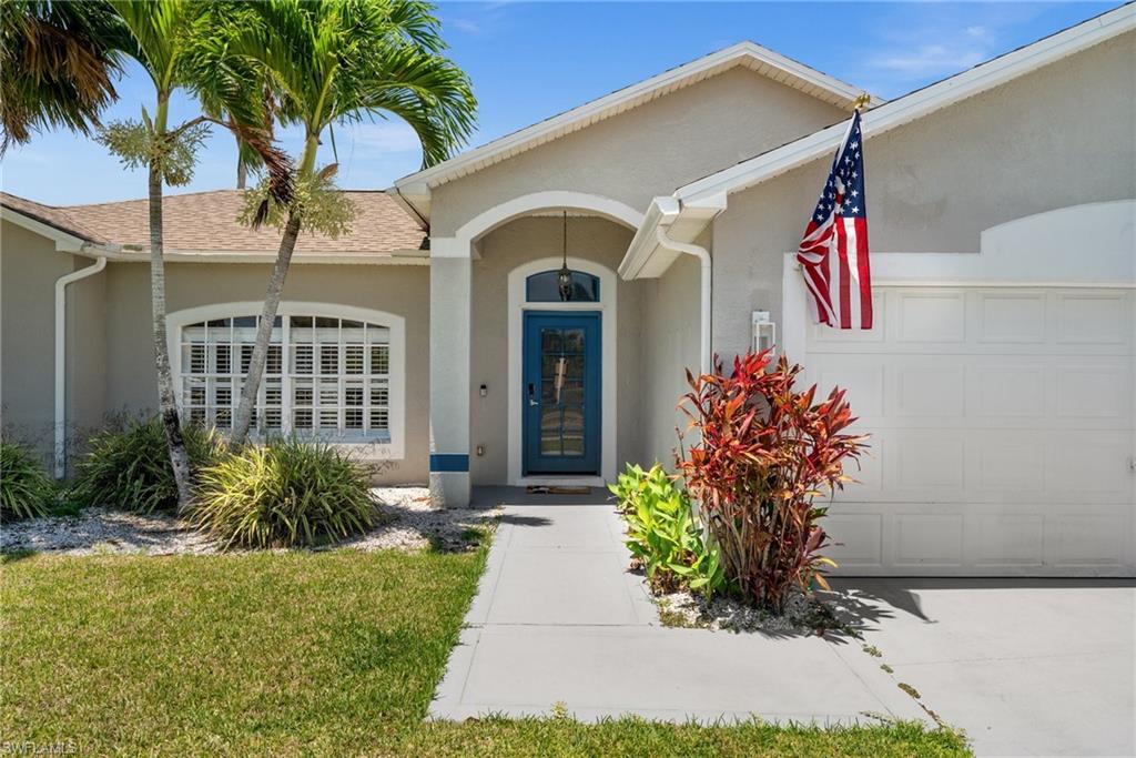 Doorway to property featuring a garage, stucco siding, and a shingled roof