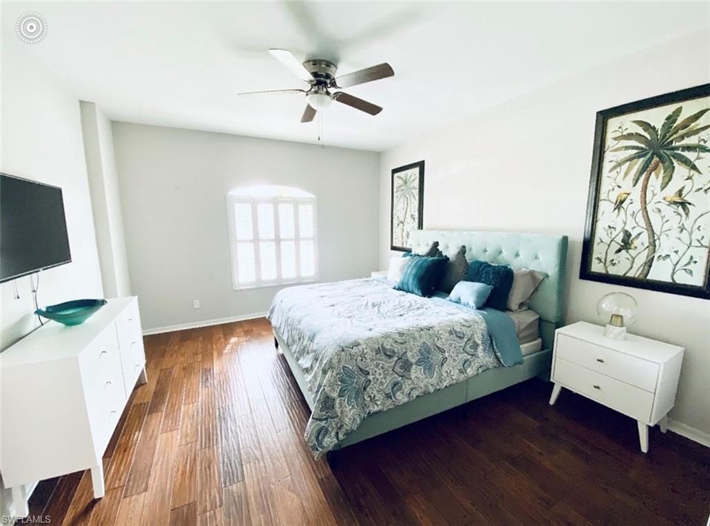 Bedroom featuring wood finished floors, baseboards, and ceiling fan
