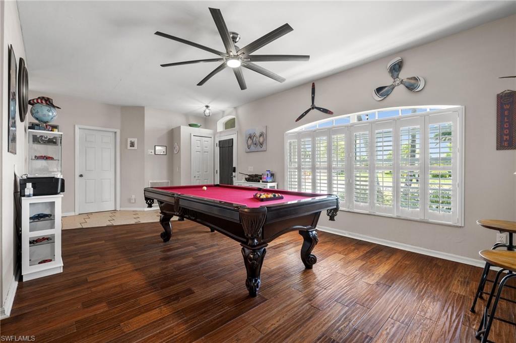 Playroom featuring pool table, a ceiling fan, wood finished floors, and baseboards