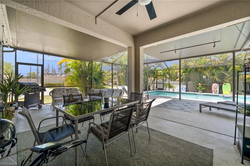 Sunroom with a ceiling fan, outdoor dining area, and a pool