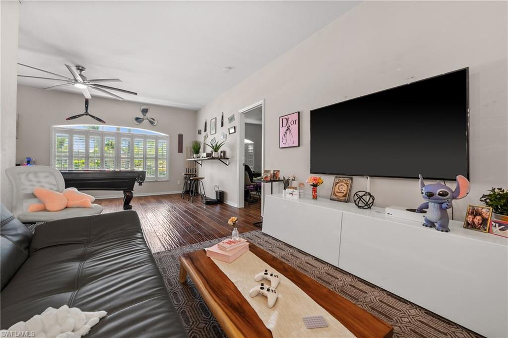 Living area featuring billiards table, wood finished floors, ceiling fan, and baseboards