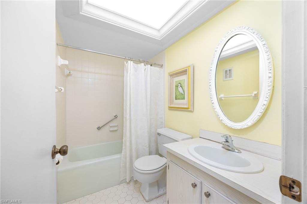 Bathroom with shower / bath combo, visible vents, vanity, and toilet
