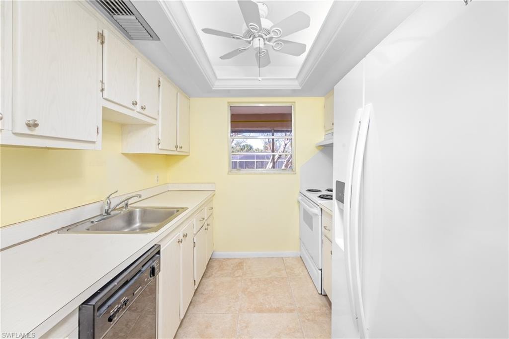 Kitchen with a sink, visible vents, white appliances, ceiling fan, and under cabinet range hood