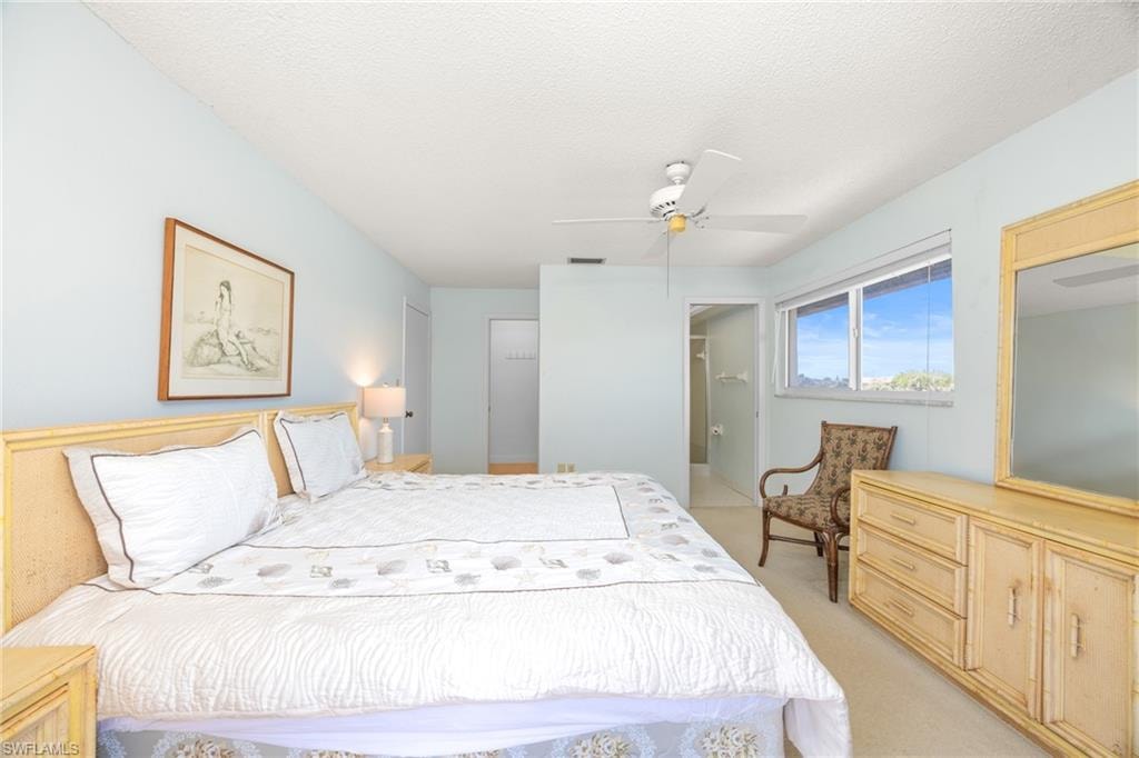 Bedroom featuring a ceiling fan and light colored carpet