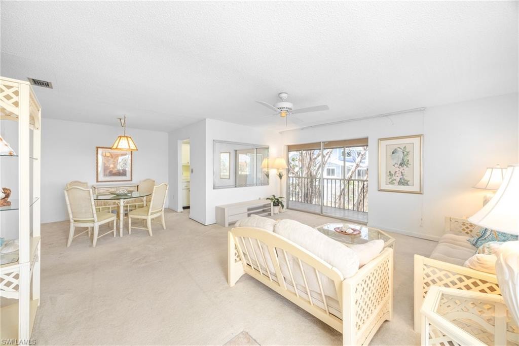 Bedroom with light carpet, visible vents, ceiling fan, and access to exterior