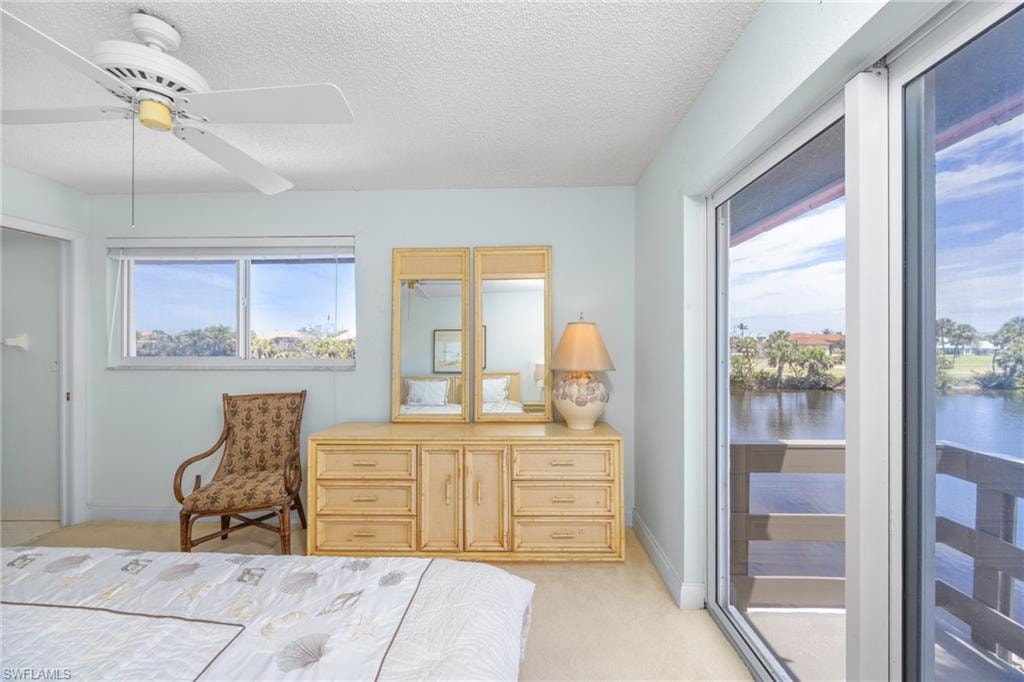 Bedroom featuring light carpet, access to exterior, and multiple windows