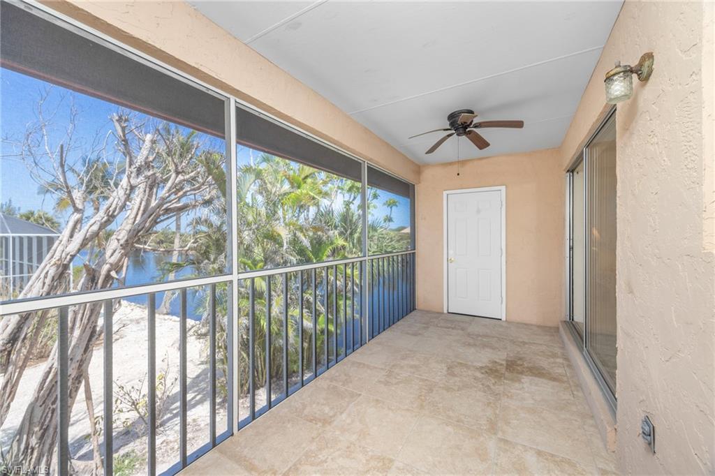 Balcony featuring a water view and ceiling fan