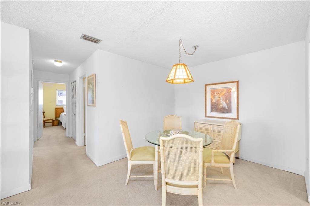 Dining room featuring light carpet, baseboards, and visible vents
